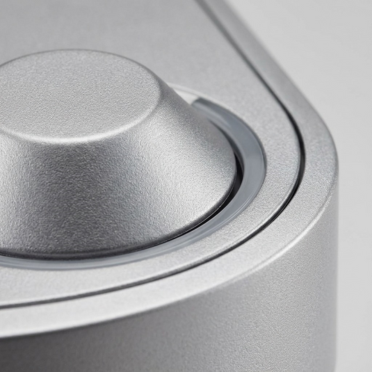 A macro photo focuses on the texture of the metallic finish and precision of the single button and indicator.