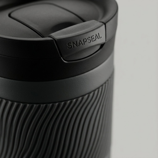 Macro close-up focusing on Contigo SNAPSEAL lid and textured rubber grip on gray tumbler.