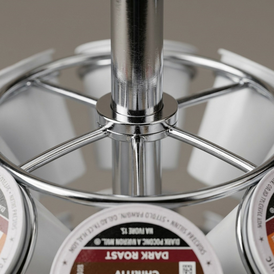 A macro photo focuses on a chrome joint of the Keurig pod carousel, highlighting the smooth metal and fine print quality on the k-cups.